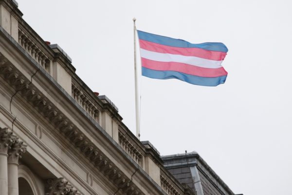 Transgender flag flying over a building with a balcony (photo credit: Foreign, Commonwealth & Development Office)