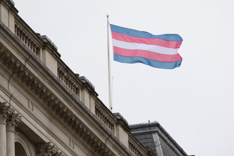 Transgender flag flying over a building with a balcony (photo credit: Foreign, Commonwealth & Development Office)