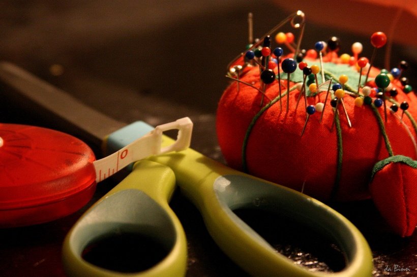 Measuring tape, scissors, and a pincushion